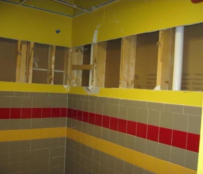 yellow bathroom wall with drywall cut out 