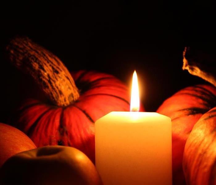 White candle in the middle of pumpkins 